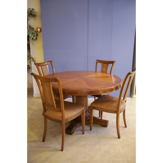Round wooden table set with four Busatto chairs.