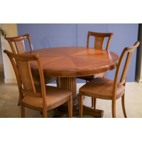 Round wooden table set with four Busatto chairs.